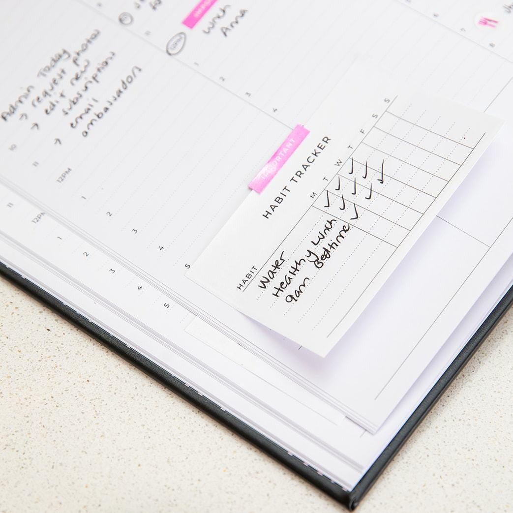 Habit Tracker Sticky Notes placed in a diary by Ronnie & Co